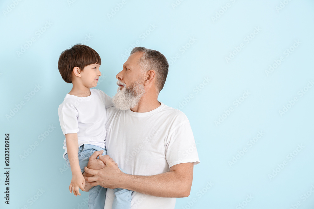 Cute little boy with grandfather on light background - obrazy, fototapety, plakaty 