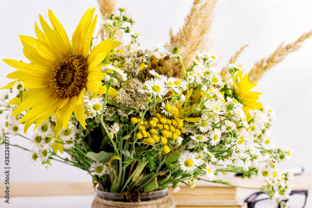 Wildflowers in a handmade vase, on a white background on the table. Copy space.