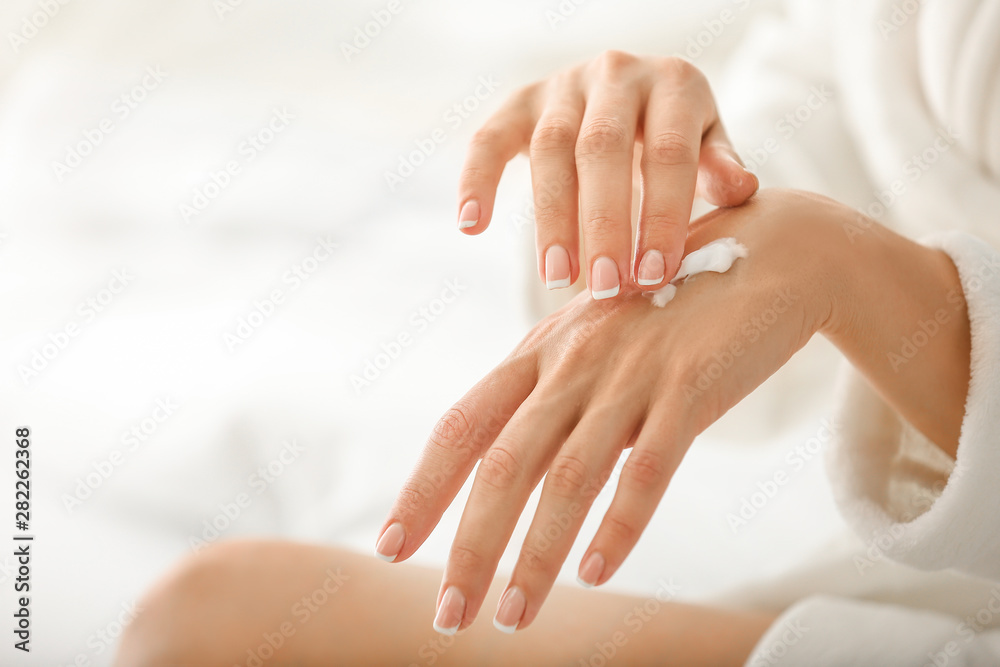 Young woman applying natural cream onto skin at home Young woman applying natural cream onto skin at home