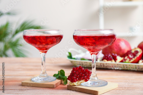 Glasses of fresh pomegranate juice on table