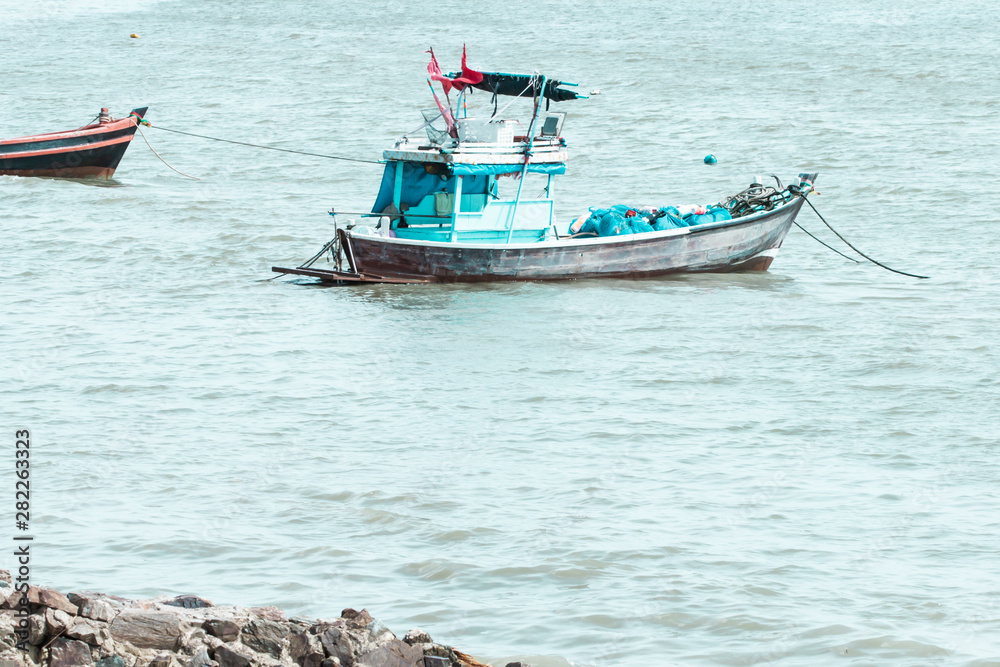 Naklejka premium Small blue fishing boat in the sea.
