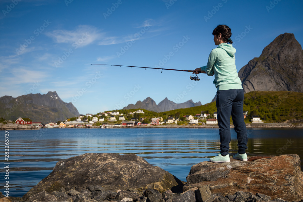 Woman fishing on Fishing rod spinning in Norway.