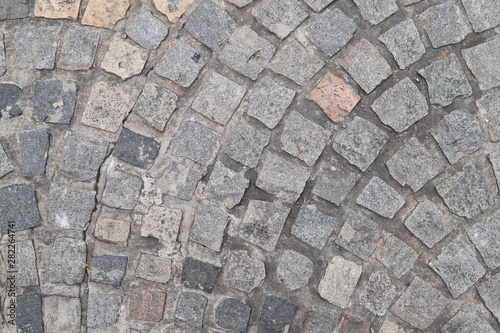 Closeup of vintage geometric stone blocks laying as floor of road.