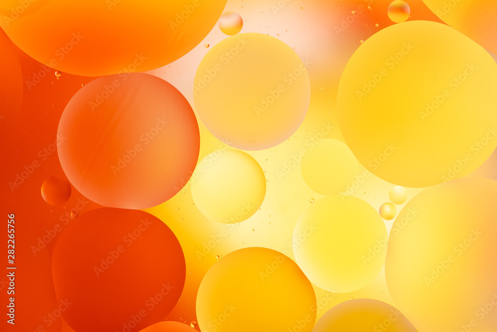 bright oily drops in water with colorful background, close-up 