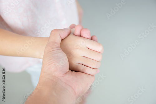 Selective focus of Father and daughter holding hand in hand
