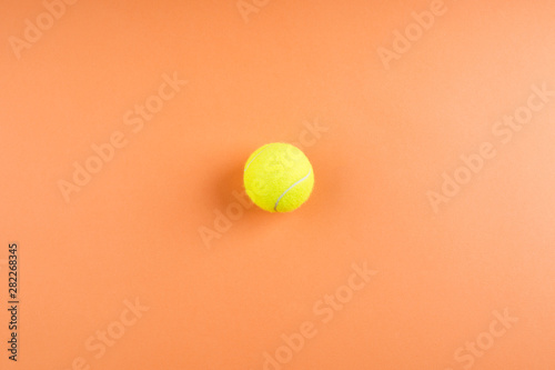 Tennis ball on orange abstract background © tenkende