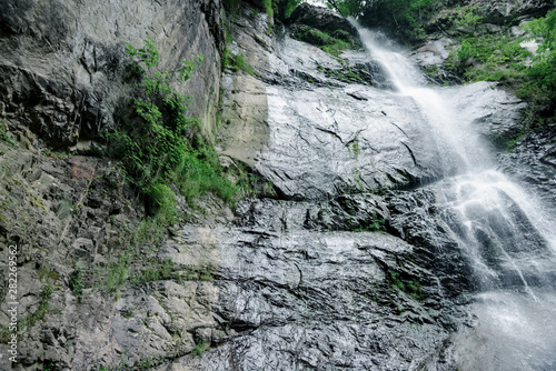 The highest and most impressive waterfall of Georgia is Mahunceti, about 30 meters high, surrounded by trees, a mountain of dark, almost black color. photo