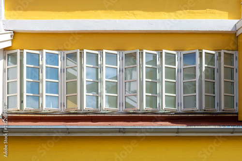 Old beautiful windows on a yellow wall. Architecture.