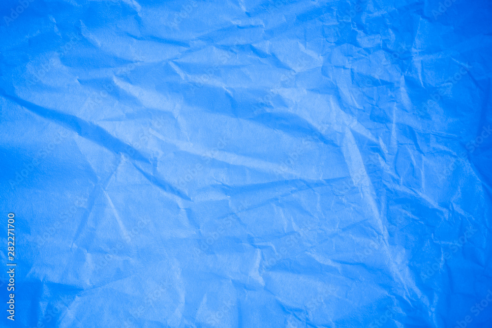 Obraz premium Crumpled blue paper background.