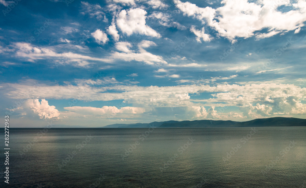 Lake Baikal. View of the sky above the lake and mountain range on the horizon.