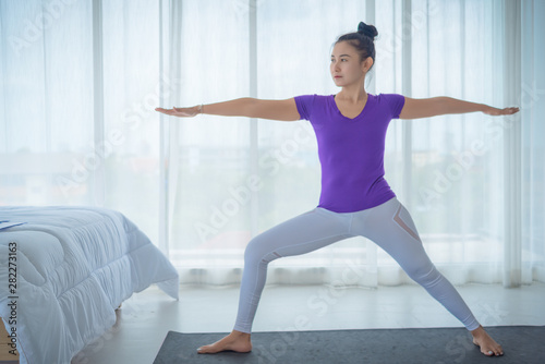 A beautiful young woman sitting in a yoga room in a calm and relaxed manner. Light  comfortable  light window background comes in the morning. Health care concepts