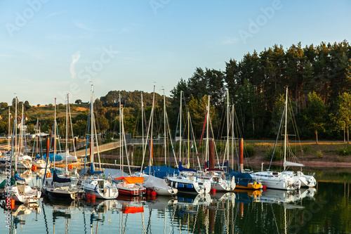 Boat station with yachts on Lake Brombach in the evening at sunset