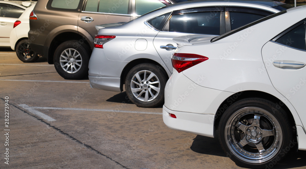 Closeup of rear, back side of white car with other cars parking in outdoor parking lot in sunny day. Closeup of rear, back side of white car with other cars parking in outdoor parking lot in sunny day.