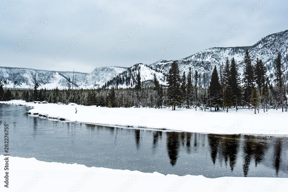 Winter scene  of a river and snow covered mountains in Yellowstone National Park, Wyoming. 
