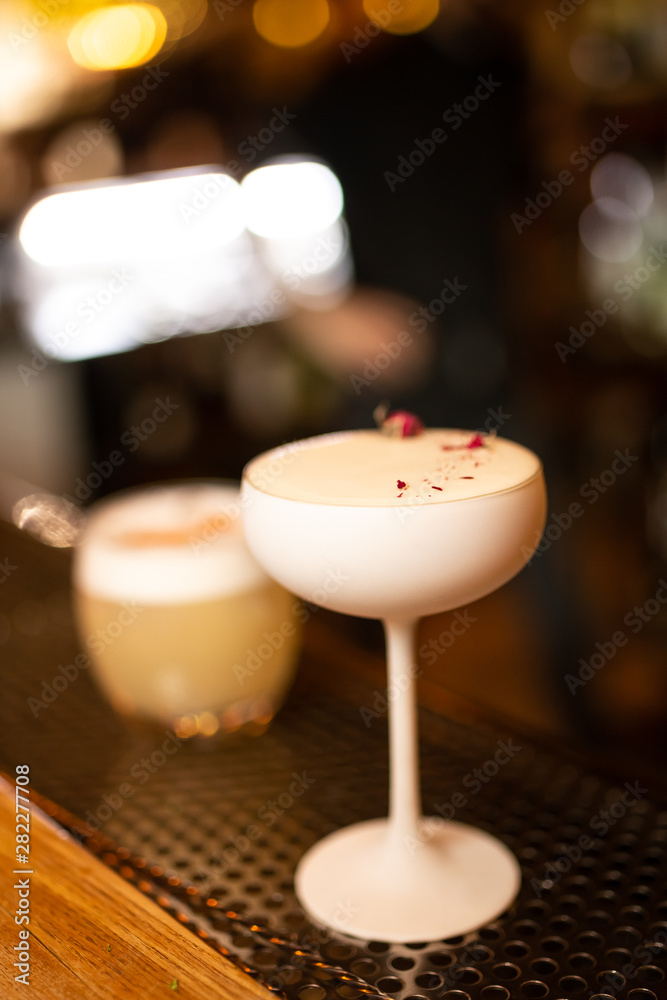 Close-up cocktail in white glass on the bar, blurred background. Close-up cocktail in white glass on the bar, blurred background.