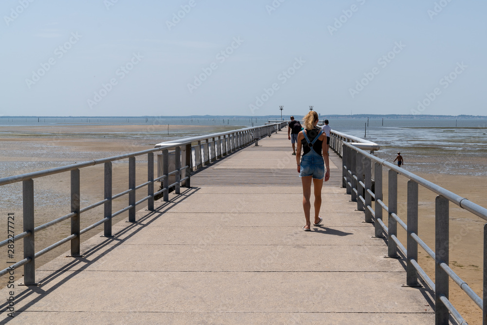 pontoon Pier of Andernos les Bains France with young woman walking behind