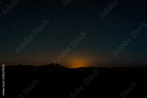 Night sky with light pollution above dunes Erg Chebbi near Merzouga, Morocco
