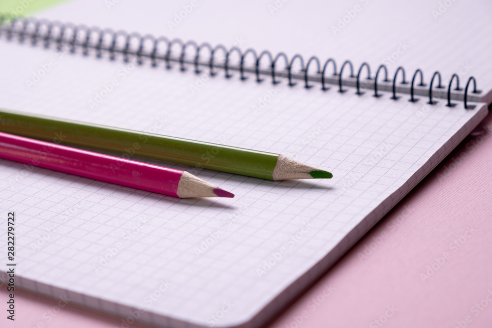 top view of a open school notebook with a spiral spring, office notepad in diagonal with pencil top view of a open school notebook with a spiral spring, office notepad in diagonal with pencil