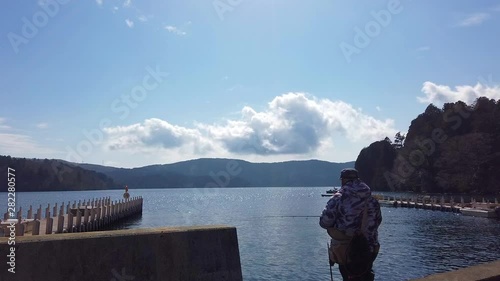 A man is fishing in Ashi Lake, Hakone Japan.