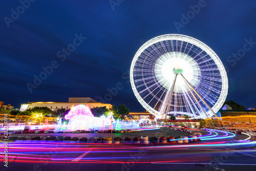 Blur light of ferris wheel in amusement park with Small quad bike for child park