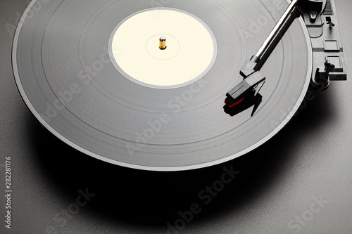 Black vinyl record player on black table background