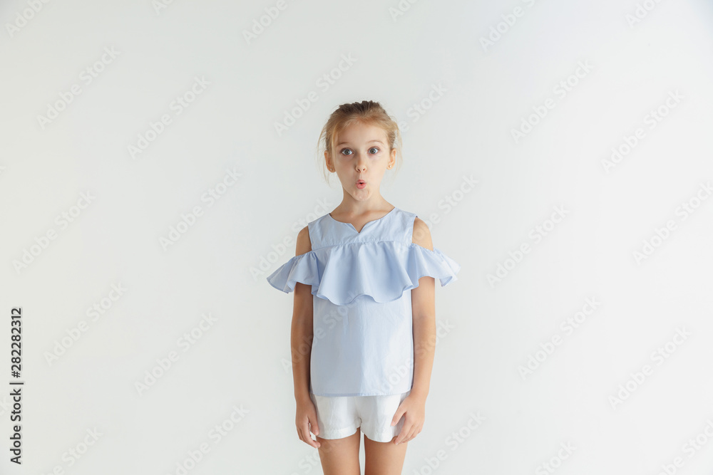 Stylish little smiling girl posing in casual clothes isolated on white studio background. Caucasian blonde female model. Human emotions, facial expression, childhood. Shocked, wondered. Stylish little smiling girl posing in casual clothes isolated on white studio background. Caucasian blonde female model. Human emotions, facial expression, childhood. Shocked, wondered.