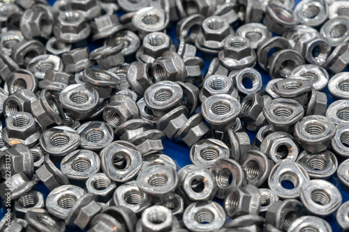 The pile of the special nuts in the container box. The nuts and bolts manufacturing process.