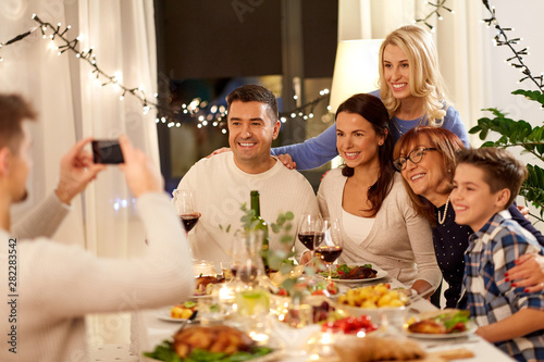 celebration  holidays and people concept - happy family having dinner party at home and taking selfie by smartphone
