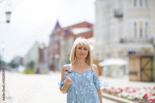 Portret happy Elegant middle aged woman walks down the street in summer day. positive. positive. happy lifestyle concept