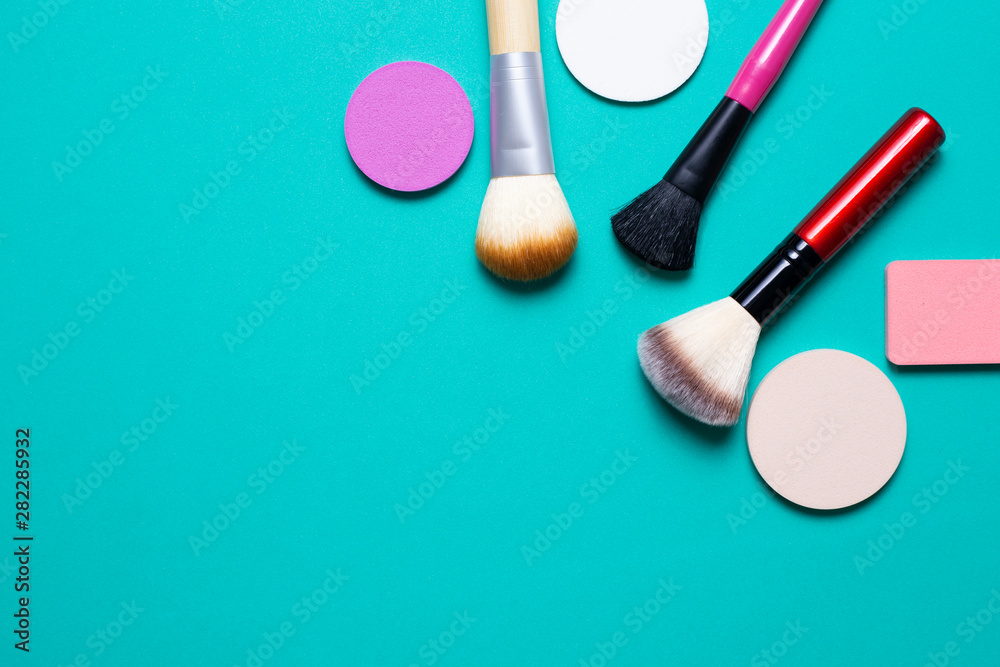 Set of colorful cosmetics on green background