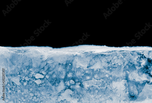 Textured hoary ice block surface on black background with cope space.