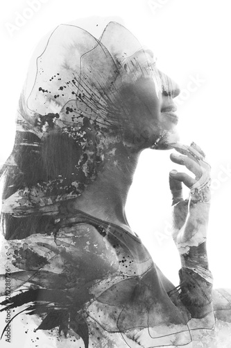 Paintography. Double Exposure profile portrait of a beautiful young woman gently touching her face combined with hand drawn ink painting with floral motifs. black and white