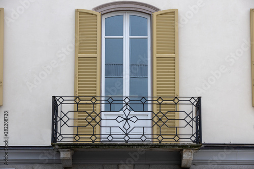 balcone in ferro battuto con persiane color senape  photo