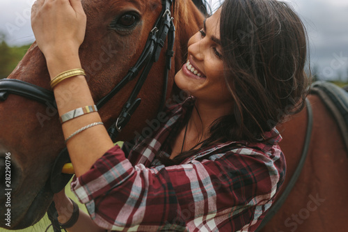 Fotobehang Smiling woman petting her horse
