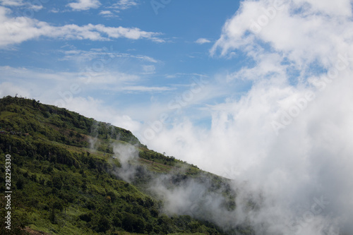 Close-up Fog and cloud mountain valley landscape In the Rainy season with blue Cloud sky background