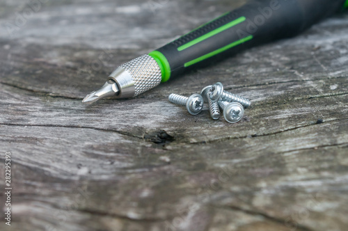small green screwdrivers on wooden background
