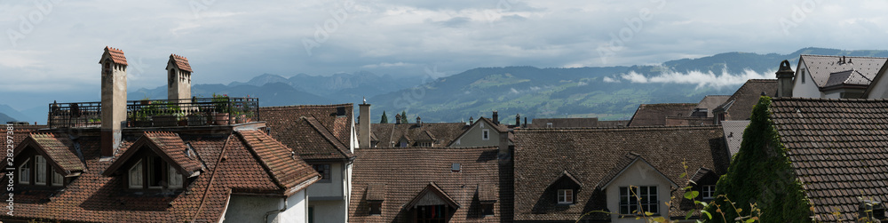 panorama view of old houses and rooftops in Europe with mountain landscape behind