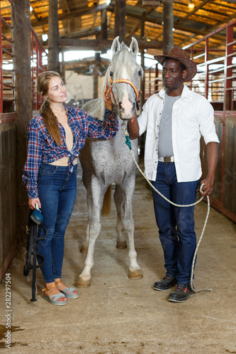 Man and girl posing near horse © JackF