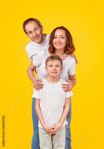 Smiling parents with kid looking at camera