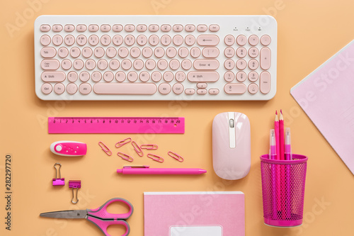 Feminine workspace with a computer and stationery to pink color on a pastel background. Flat lay office table desk frame.