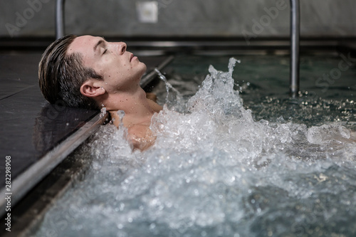Attractive male lying in bubbling jacuzzi