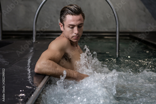 Pensive male relaxing in whirlpool bath