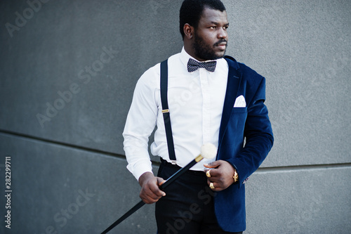 Photo Handsome fashionable african american man in formal wear and bow tie with walking stick