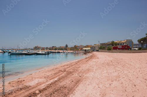 Marzamemi Sicily, beautiful popular beach along the village with tourist port and boats