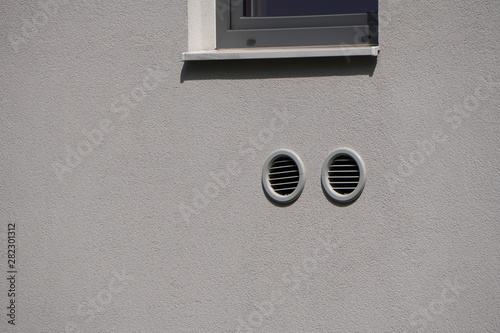 round white holes for ventilation in the wall, forced ventilation in the wall of an old apartment building.