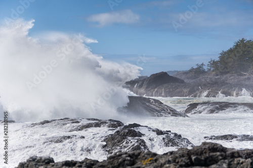 big wave crashing at the rocks and cliff of the coast on sunny Vancouver island