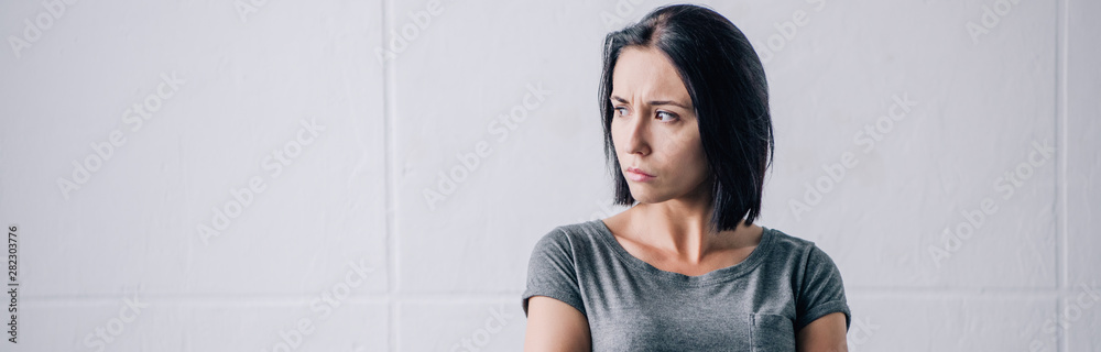 panoramic shot of depressed brunette woman looking away at home panoramic shot of depressed brunette woman looking away at home