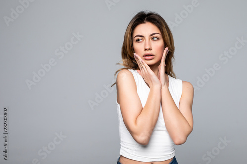 Young woman shocked because of the bad news, isolated on a gray background