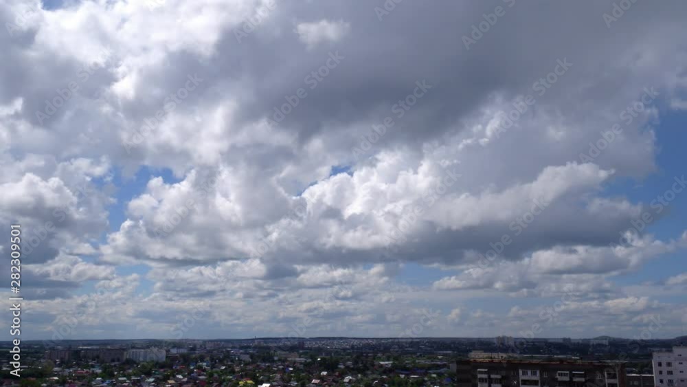 White clouds running over city, summer day-time. Skyscape timelaps. White clouds running over city, summer day-time. Skyscape timelaps.