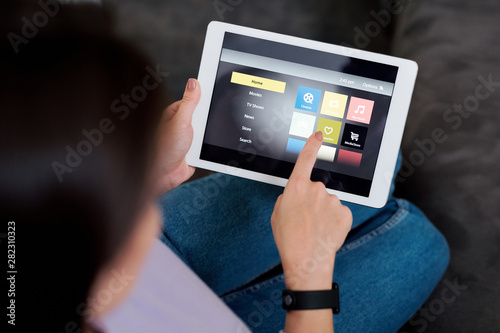 Human pointing at icon on touchpad display while choosing something to watch